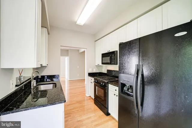 a kitchen with granite countertop a refrigerator stove and sink