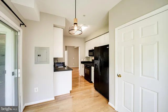 a view of a kitchen with a refrigerator a stove top oven a refrigerator a kitchen wooden floor and windows