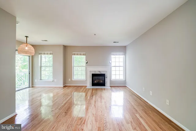 wooden floor fireplace and windows in an empty room