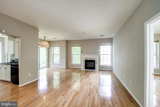 a view of empty room with wooden floor and fireplace