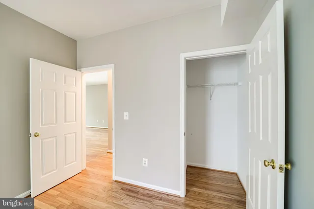 an empty room with wooden floor and closet