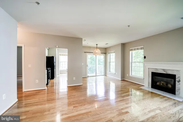 a view of an empty room with window and fire place