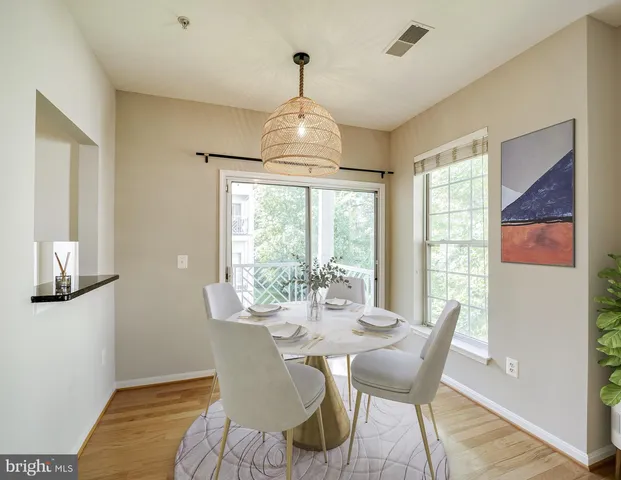 a dining room with furniture a chandelier and wooden floor