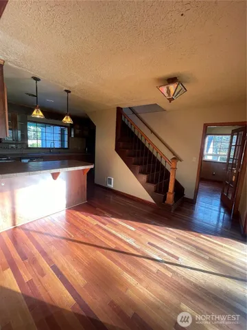 a view of a living room and kitchen with furniture wooden floor and windows