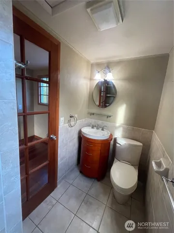 a bathroom with a toilet sink and mirror