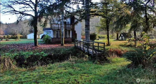 a view of a backyard with table and chairs and a large tree
