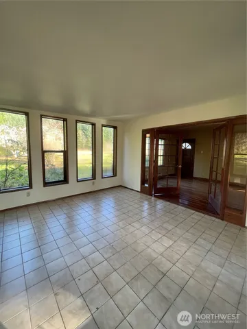 a view of an empty room with window and fireplace