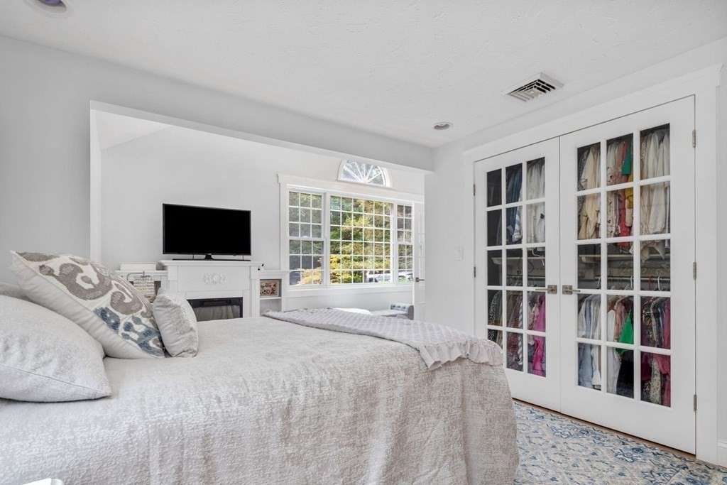 155 Whiting Street Hingham, MA 02043 - Photo 12 of 30 a bedroom with a bed and a flat screen tv