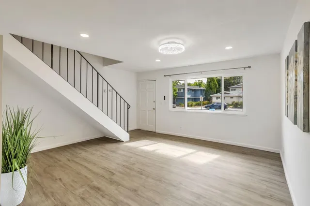 a white painted room with a window and wooden floor