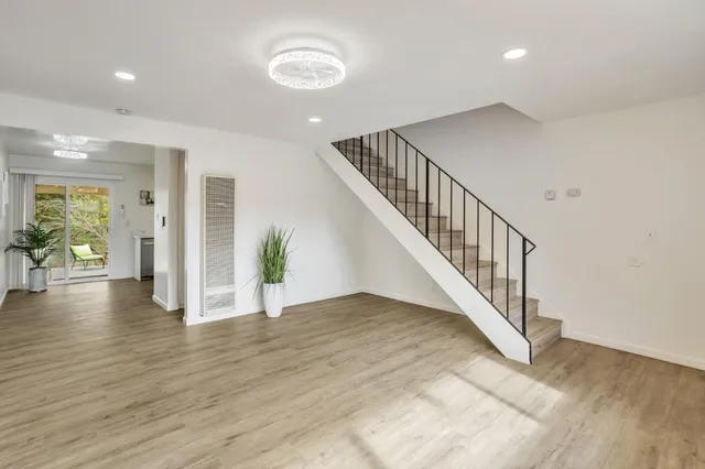 a view of a hallway with potted plants and wooden floor