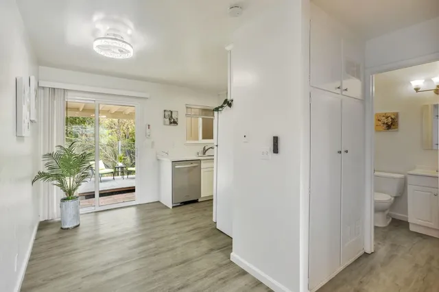 a kitchen with a refrigerator a stove top oven a counter space and wooden floor