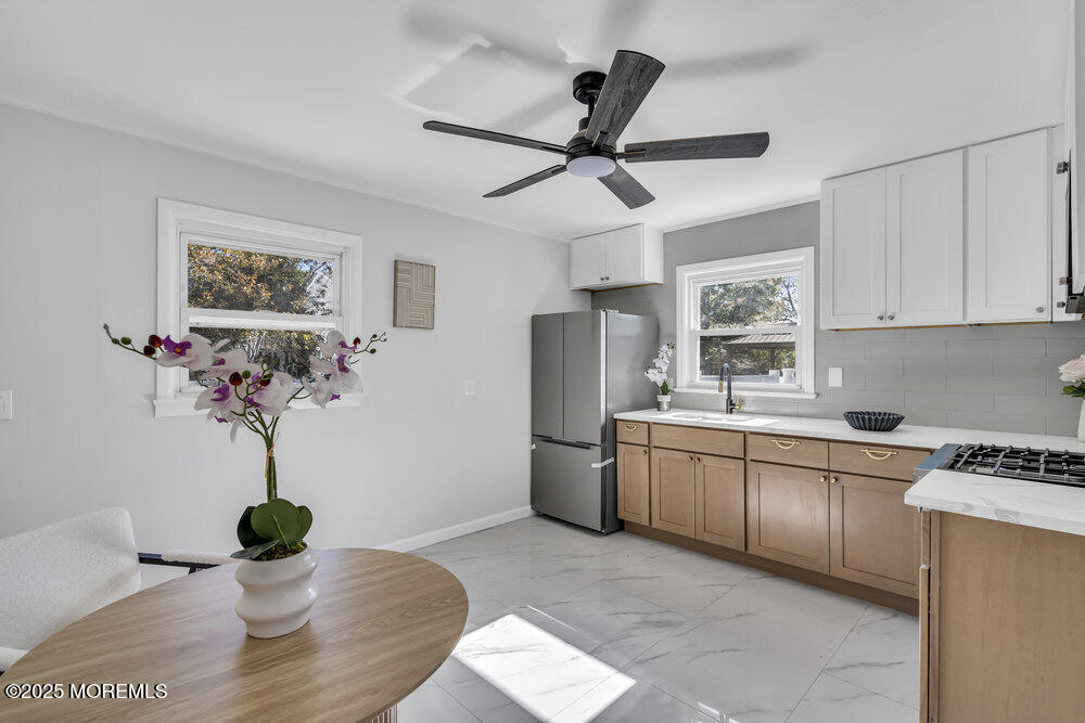 1202 Sunset Avenue Point Pleasant, NJ 08742 - Photo 15 of 23 a kitchen with stainless steel appliances a white table a stove a sink and a window