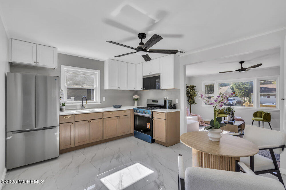1202 Sunset Avenue Point Pleasant, NJ 08742 - Photo 6 of 23 a kitchen with stainless steel appliances granite countertop a refrigerator a sink dishwasher a stove a dining table and chairs with wooden floor