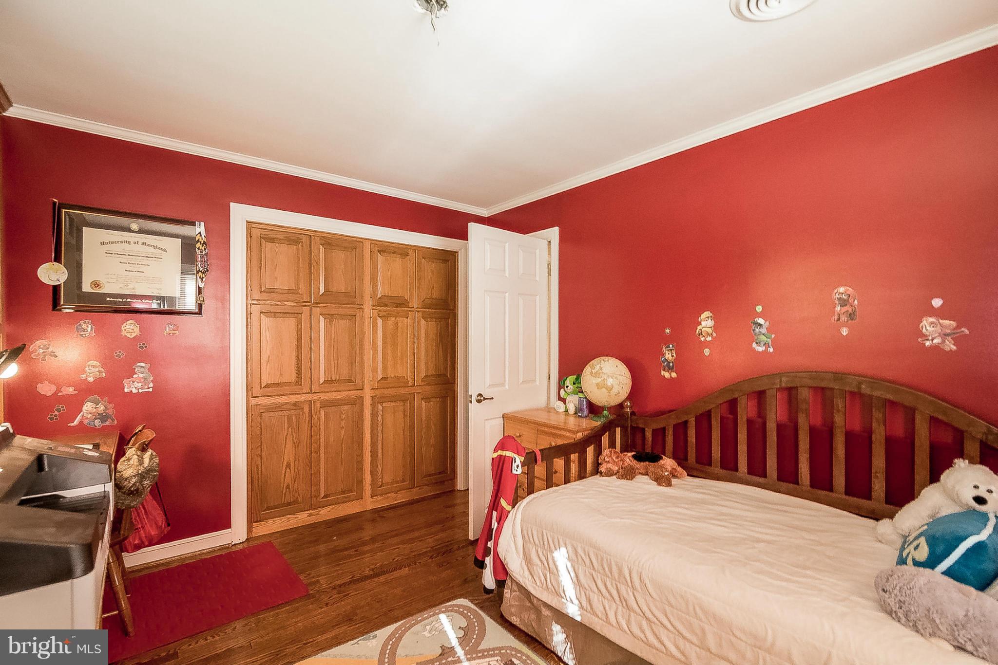 7707 Ridge Road Frederick, MD 21702 - Photo 17 of 30 a bedroom with a bed and dresser with wooden floor