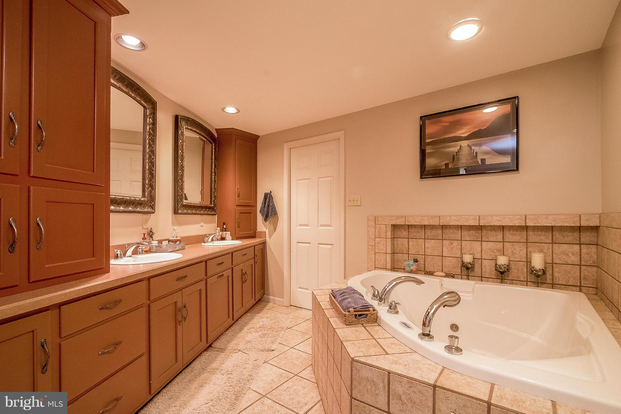 7707 Ridge Road Frederick, MD 21702 - Photo 20 of 30 a bathroom with a tub a double vanity sink and mirror