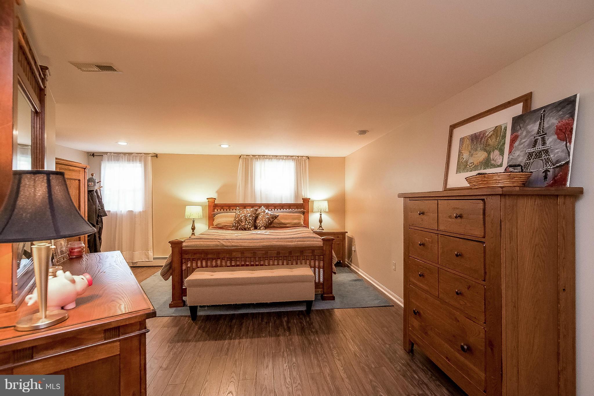 7707 Ridge Road Frederick, MD 21702 - Photo 23 of 30 a spacious bedroom with a bed and a lamp on the dresser