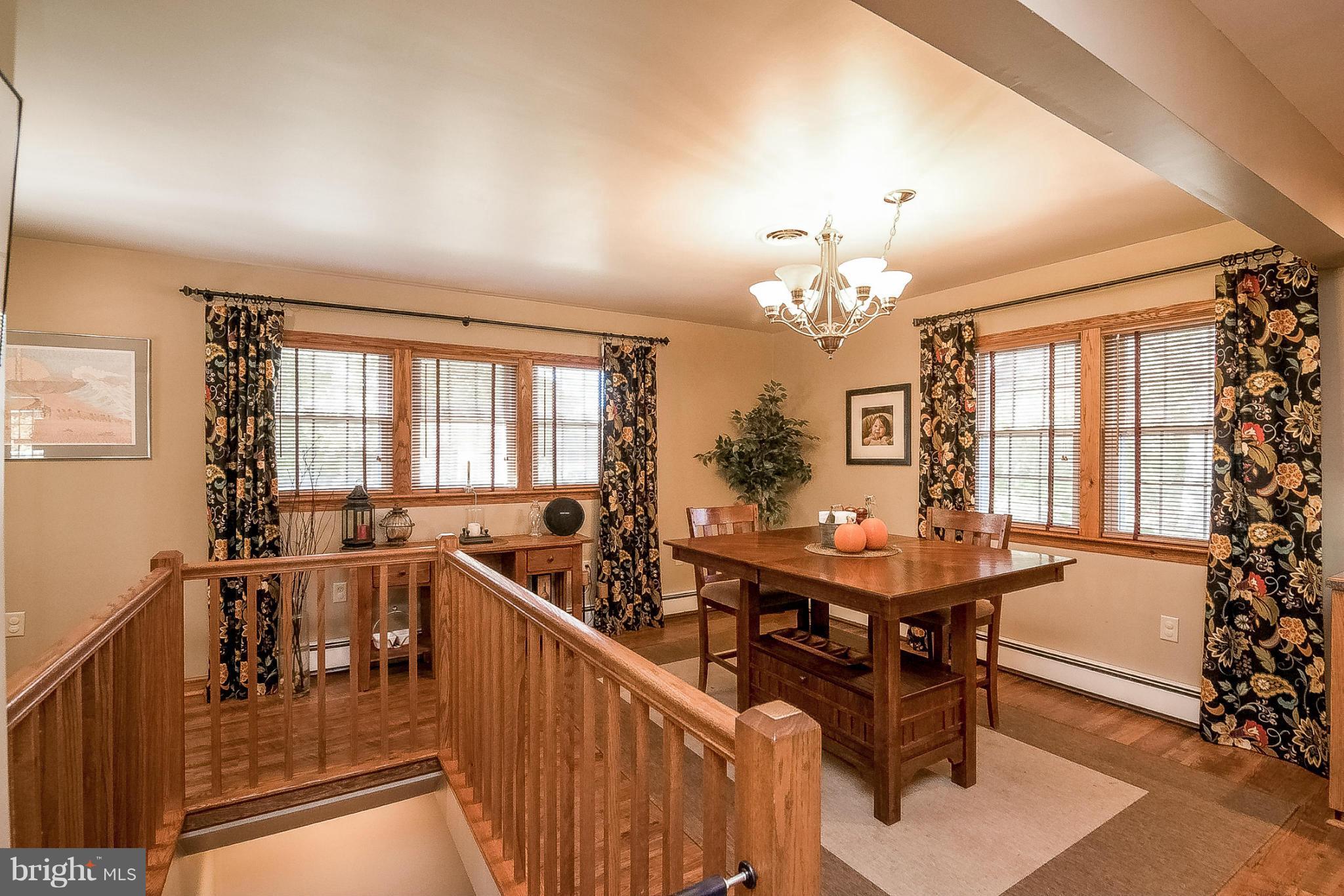 7707 Ridge Road Frederick, MD 21702 - Photo 7 of 30 a dining room with furniture a chandelier and wooden floor
