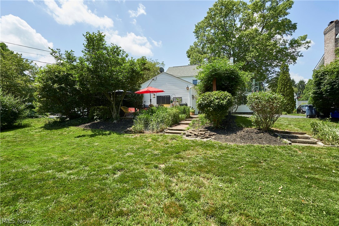 183 Overwood Road Akron, OH 44313 - Photo 30 of 34 Expansive rear yard featuring a verdant lawn, mature trees, and established shrubbery