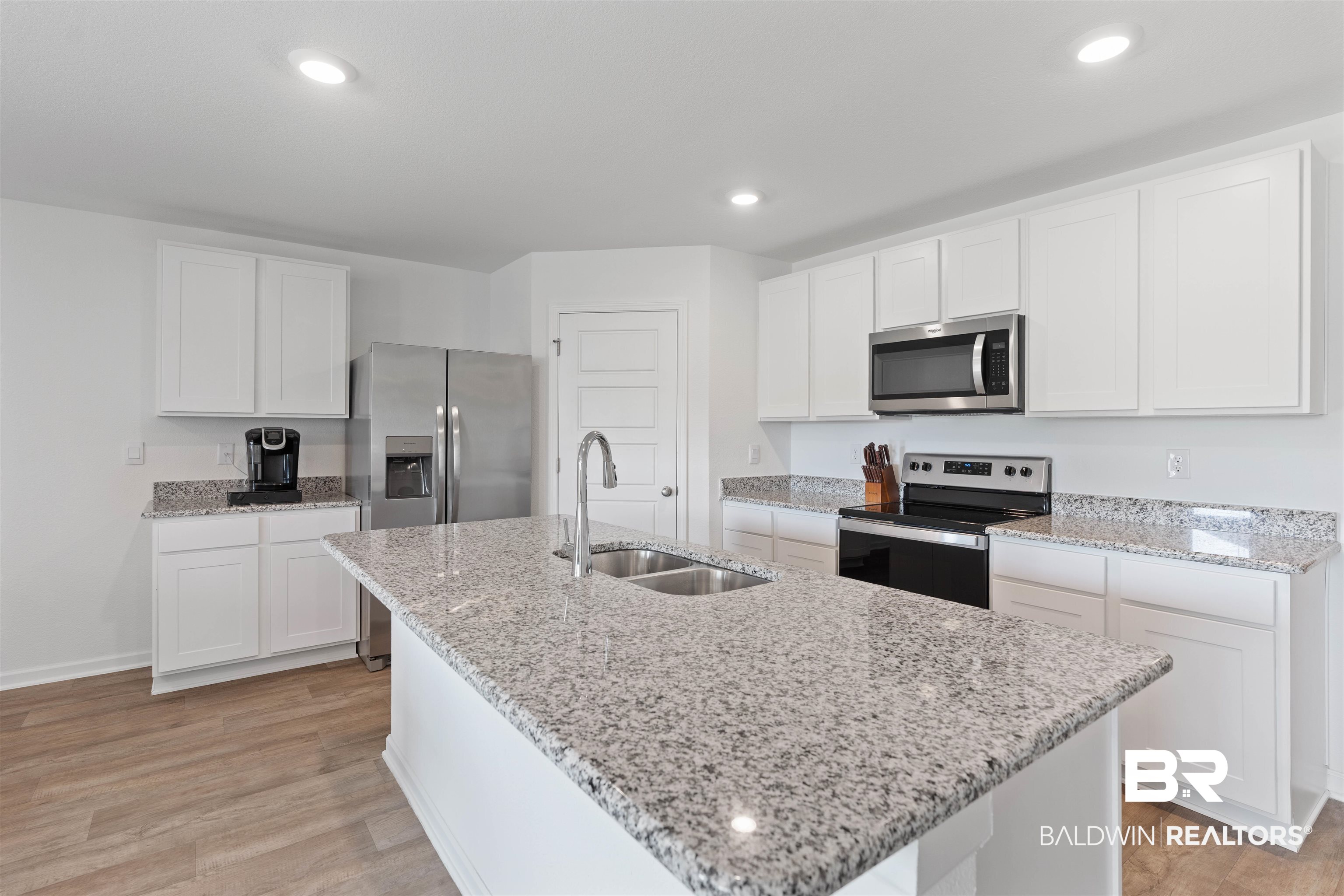 15030 Forsythia Loop Silverhill, AL 36576 - Photo 9 of 33 Kitchen with appliances with stainless steel finishes, white cabinets, light stone countertops, light wood-type flooring, and recessed lighting