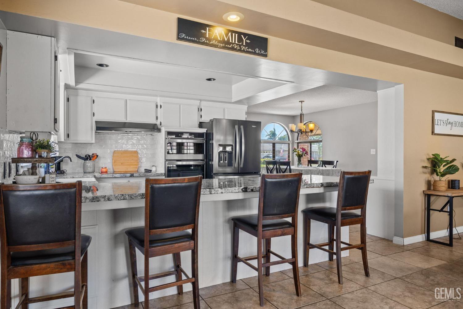 Undisclosed Address Bakersfield, CA 93311 - Photo 15 of 40 a kitchen with a dining table chairs and refrigerator