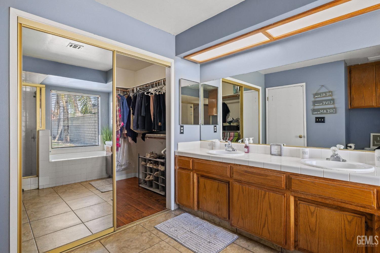 Undisclosed Address Bakersfield, CA 93311 - Photo 29 of 40 a bathroom with a double vanity sink and a mirror