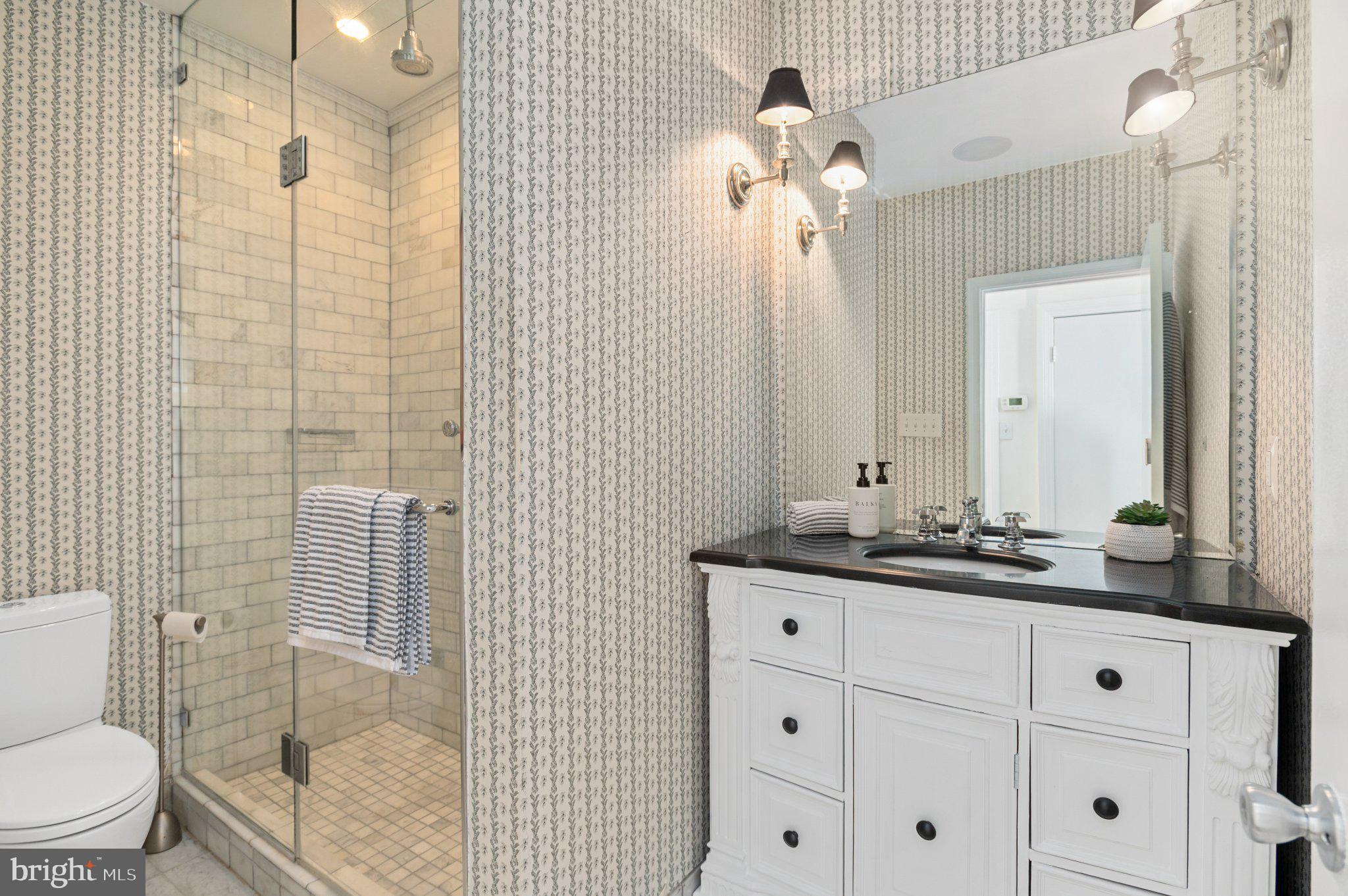 3299 K Street Northwest, Unit 401 Washington, DC 20007 - Photo 9 of 18 a bathroom with a toilet a sink and mirror
