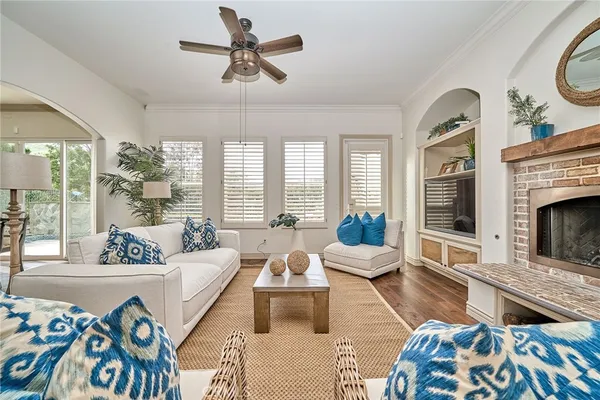 a kitchen with stainless steel appliances kitchen island granite countertop a refrigerator a stove a sink and white cabinets with wooden floor