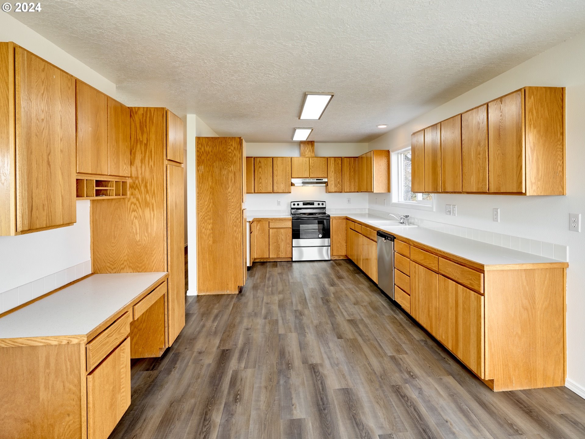 12795 Beck Road Dallas, OR 97338 - Photo 9 of 48 a kitchen with stainless steel appliances granite countertop a stove a sink dishwasher and a refrigerator with wooden floor