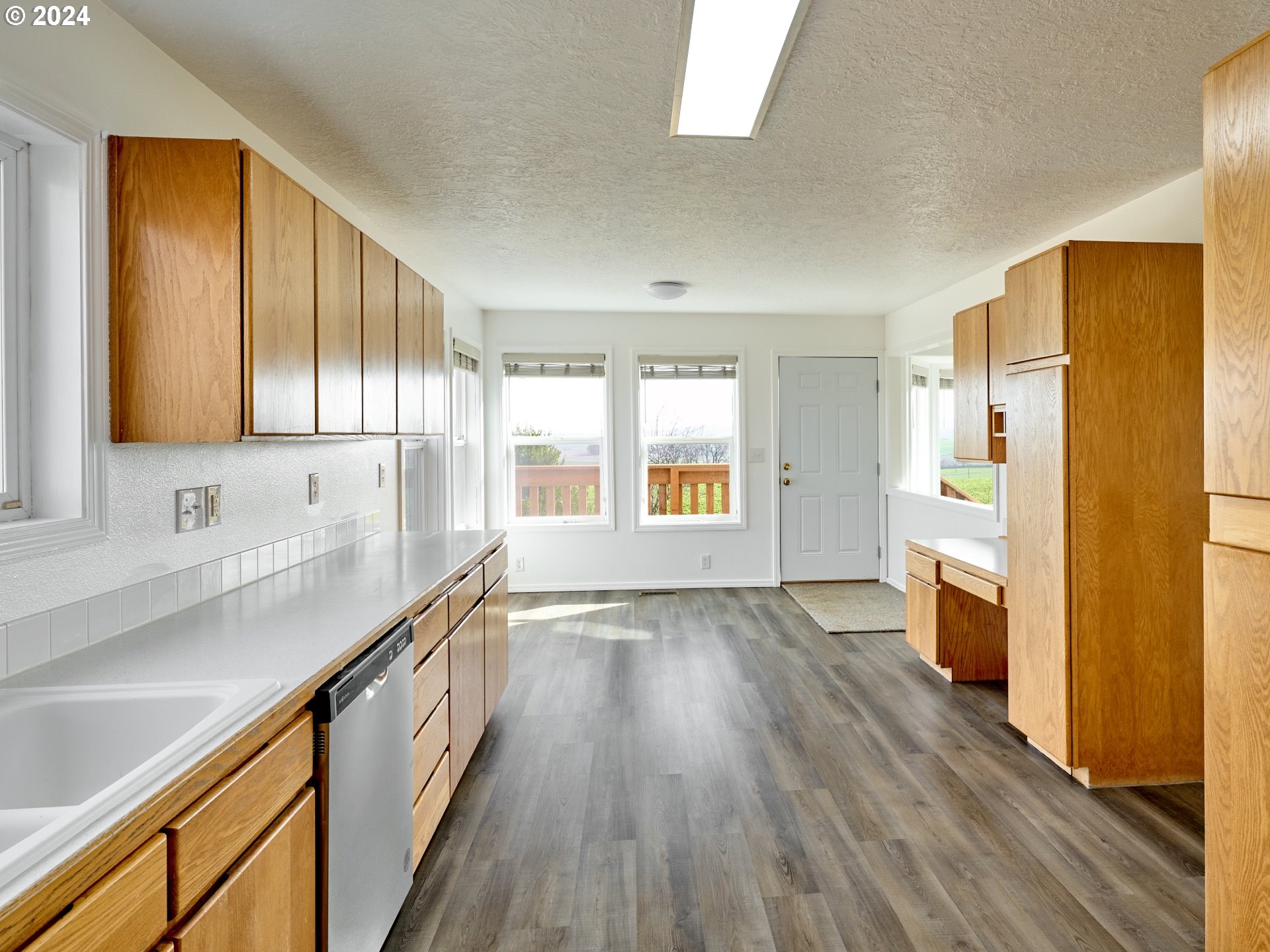 12795 Beck Road Dallas, OR 97338 - Photo 10 of 48 a view of a kitchen with a sink wooden cabinets and a window