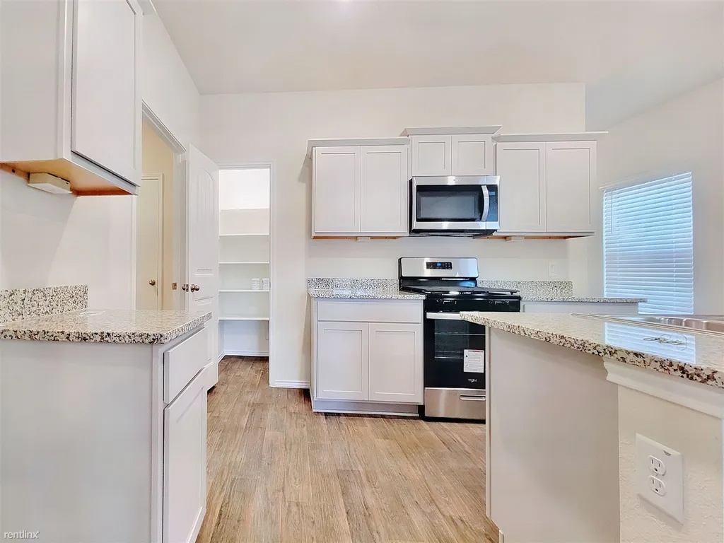 419 Sickle Loop Kyle, TX 78640 - Photo 5 of 35 A well-appointed kitchen features ample counter space, bright cabinetry, and modern cooking appliances.