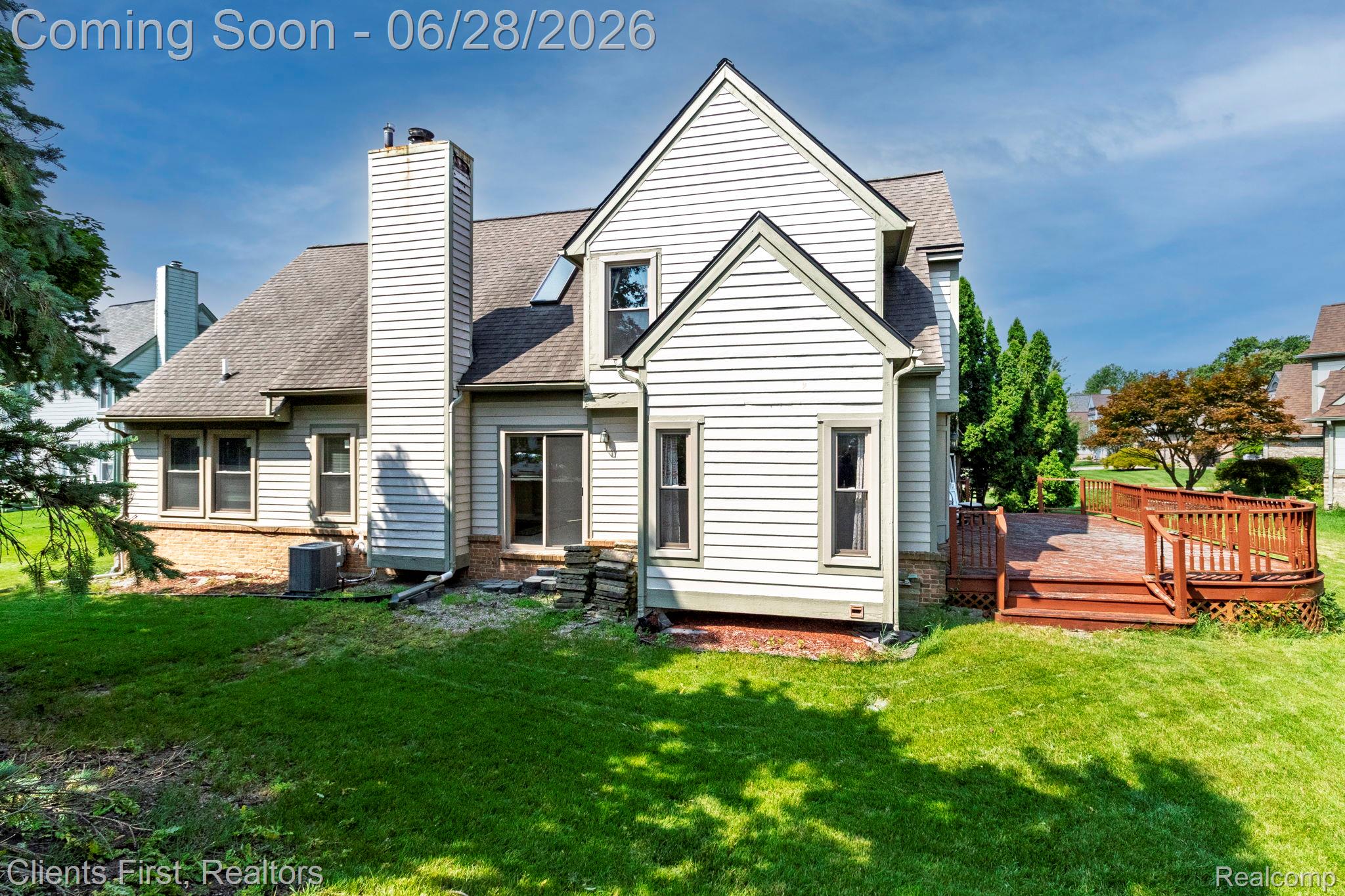 Expansive rear yard with a multi-level wood deck and established trees