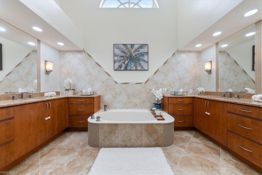 171 Via Napoli Naples, FL 34105 - Photo 20 of 45 a spacious bathroom with a tub a double vanity sink and a mirror
