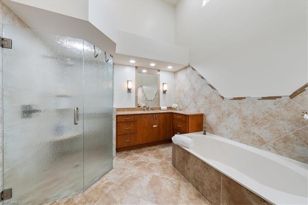 171 Via Napoli Naples, FL 34105 - Photo 21 of 45 a bathroom with a bathtub a double vanity sink and mirror