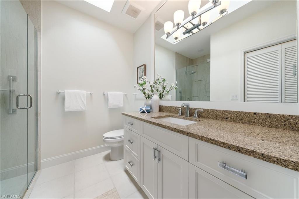171 Via Napoli Naples, FL 34105 - Photo 24 of 45 a bathroom with a granite countertop sink a toilet and a mirror