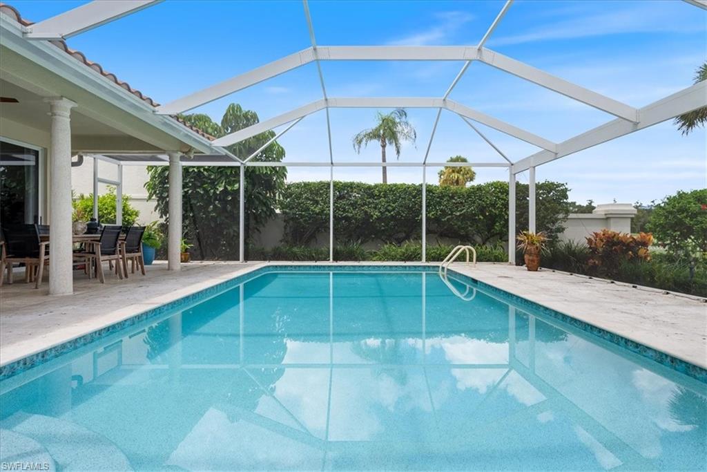 171 Via Napoli Naples, FL 34105 - Photo 33 of 45 a swimming pool with lawn chairs and potted plants
