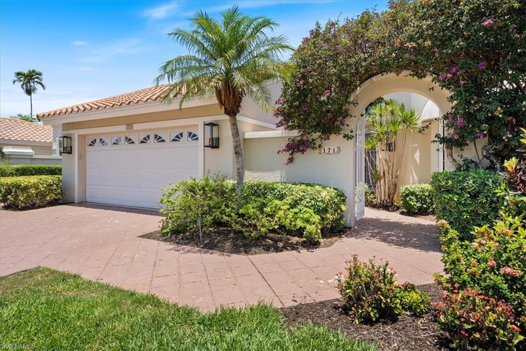 171 Via Napoli Naples, FL 34105 - Photo 4 of 45 a front view of a house with a yard and garage