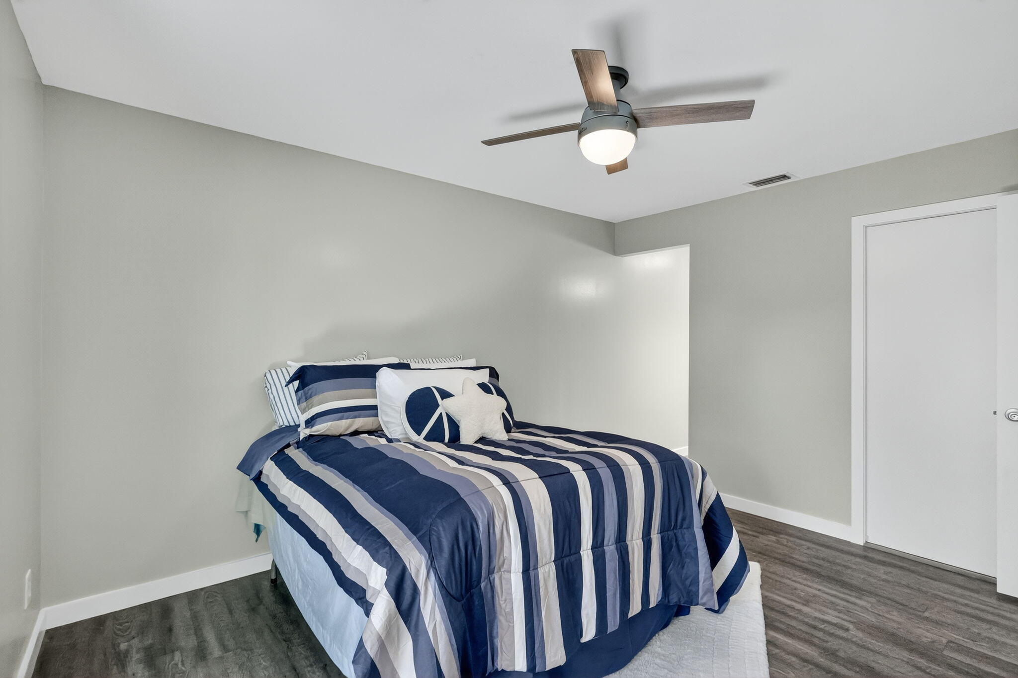 5785 Southeast Collins Avenue Stuart, FL 34997 - Photo 19 of 49 a bed room with a bed and a ceiling fan