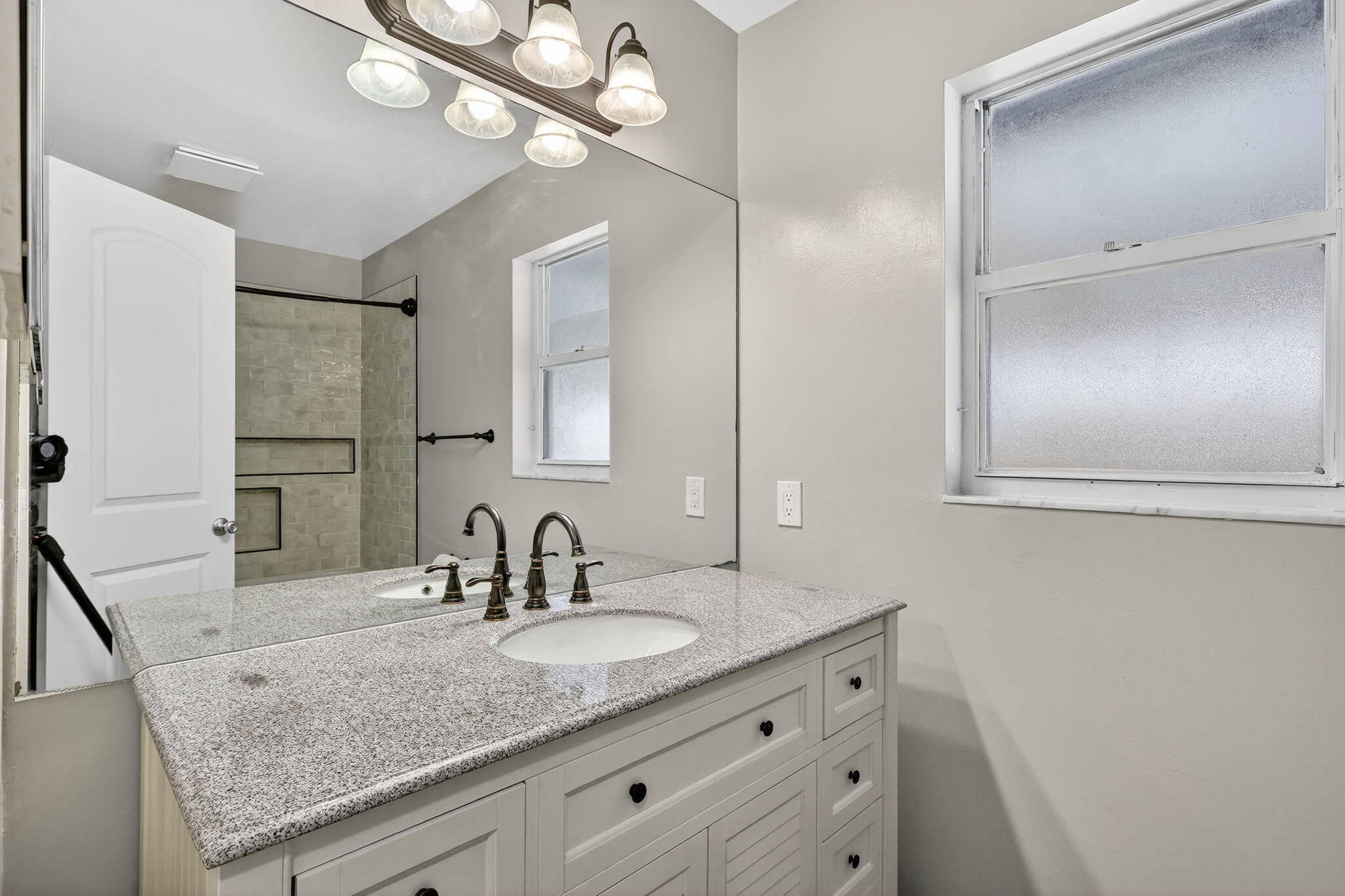 5785 Southeast Collins Avenue Stuart, FL 34997 - Photo 27 of 49 a bathroom with double vanity and a mirror