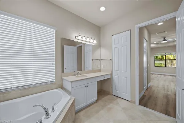 a bathroom with a tub sink shower and mirror