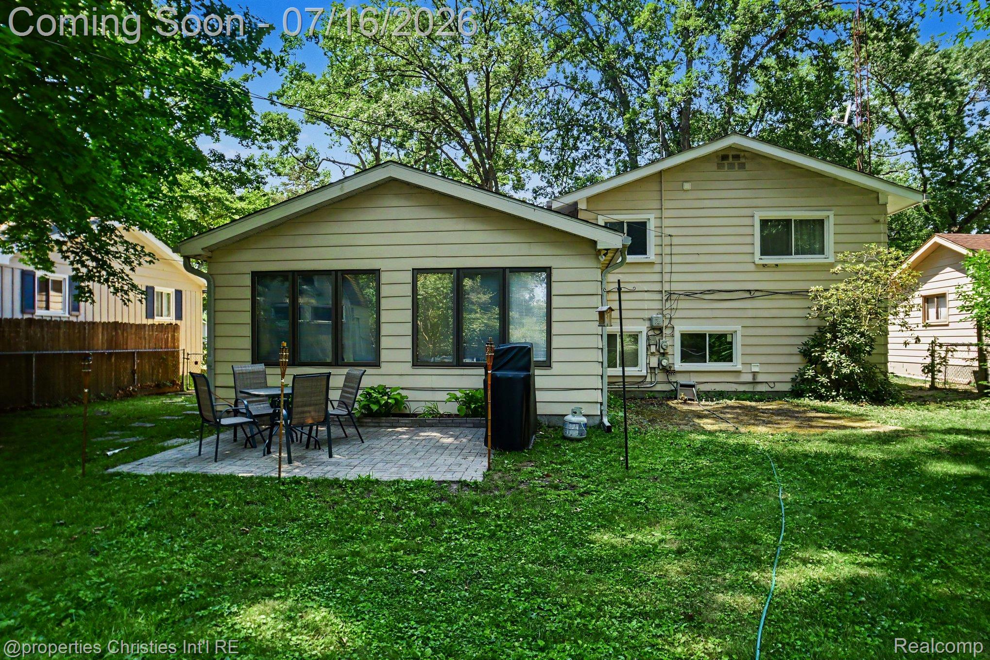 3304 Riverside Drive Port Huron, MI 48060 - Photo 24 of 26 Spacious backyard featuring a paver patio area, mature trees, and a two-story exterior with horizontal siding
