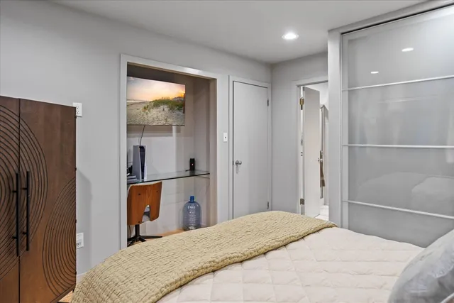 a bedroom with a bed and a large mirror