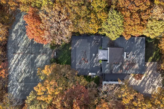 a view of a wooden house with a large tree