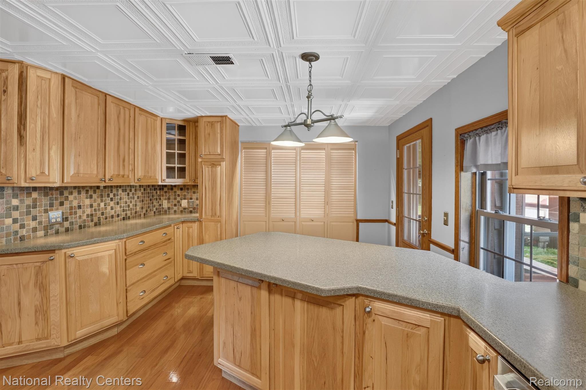 127 West Albain Road Petersburg, MI 49270 - Photo 30 of 61 Kitchen featuring wood cabinetry, stone-finish countertops, tile backsplash, wood-finish flooring, and a coffered ceiling