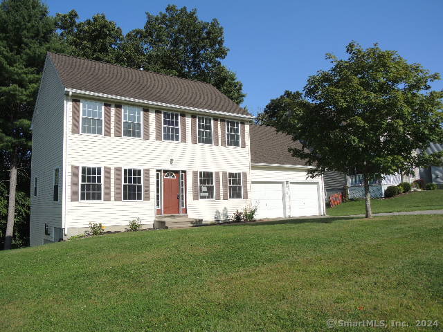 a front view of house with yard and green space