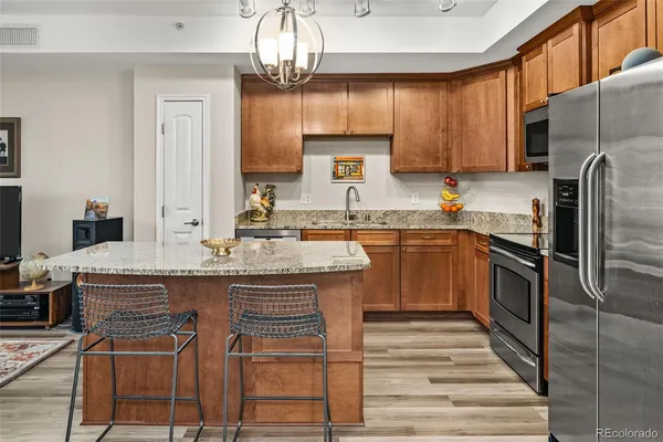 a kitchen with stainless steel appliances granite countertop a sink stove and refrigerator
