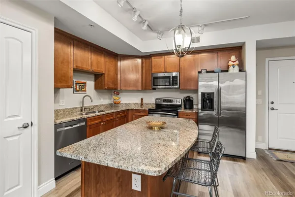 a kitchen with kitchen island granite countertop a center island and stainless steel appliances
