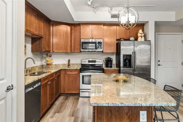 a kitchen with stainless steel appliances granite countertop a sink refrigerator and microwave