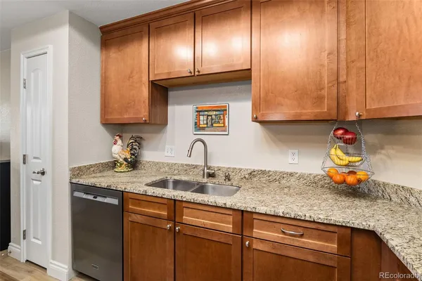 a kitchen with granite countertop stainless steel appliances a sink window and cabinets