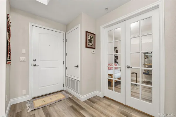 an empty room with wooden floor closet and windows