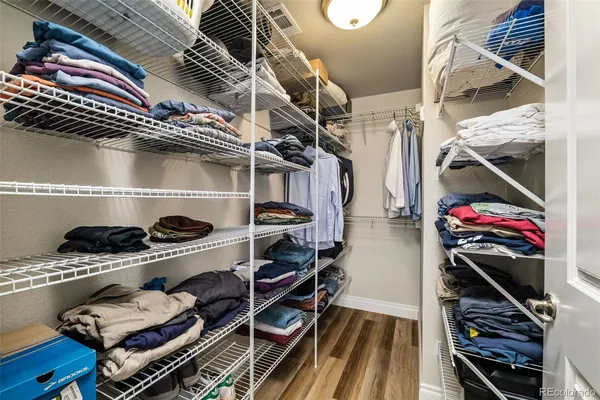 a view of walk in closet with clothes and shoes